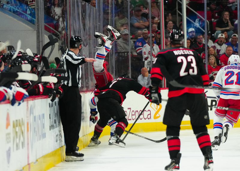 May 11, 2024; Raleigh, North Carolina, USA; Carolina Hurricanes defenseman Dmitry Orlov (7) checks New York Rangers center Jonny Brodzinski (22) during the third period in game four of the second round of the 2024 Stanley Cup Playoffs at PNC Arena. Mandatory Credit: James Guillory-USA TODAY Sports