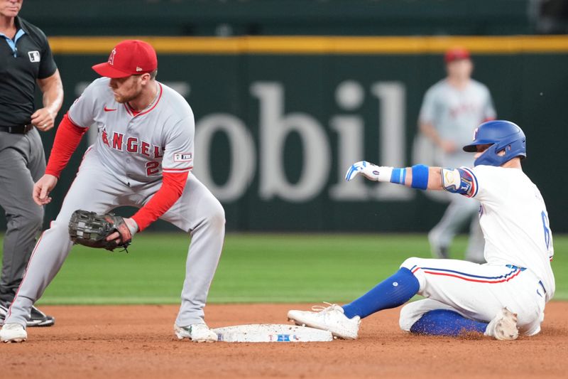 Sep 7, 2024; Arlington, Texas, USA; Texas Rangers third baseman Josh Jung (6) slides on a double ahead of the throw to Los Angeles Angels second baseman Brandon Drury (23) during the eighth inning at Globe Life Field. Mandatory Credit: Jim Cowsert-Imagn Images