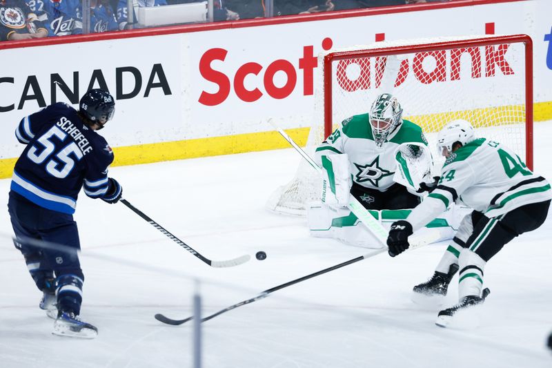 Mar 14, 2025; Winnipeg, Manitoba, CAN;  Dallas Stars goalie Jake Oettinger (29) makes a save on a shot by Winnipeg Jets forward Mark Scheifele (55) during the third period at Canada Life Centre. Mandatory Credit: Terrence Lee-Imagn Images