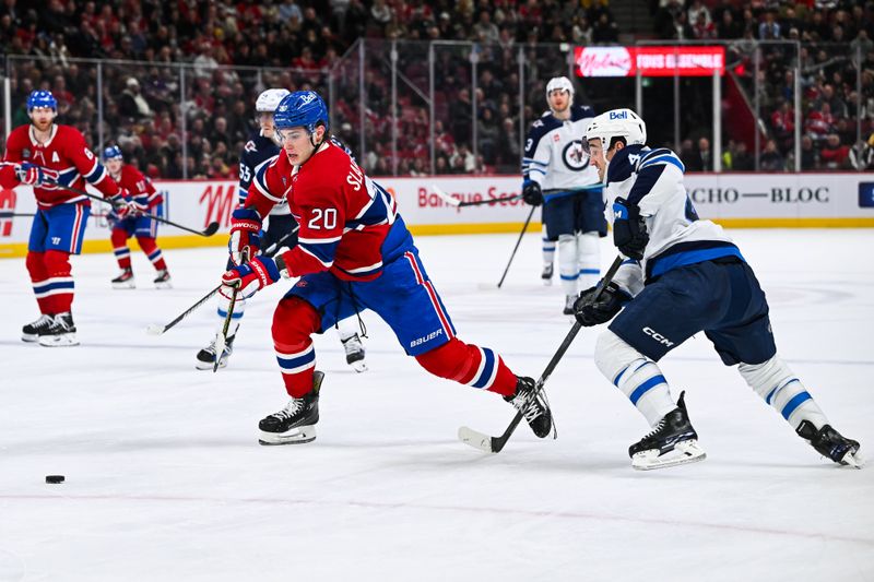 Jan 28, 2025; Montreal, Quebec, CAN; Montreal Canadiens left wing Juraj Slafkovsky (20) plays the puck agianst Winnipeg Jets defenseman Neal Pionk (4) during the second period at Bell Centre. Mandatory Credit: David Kirouac-Imagn Images