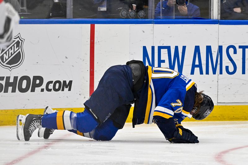 Mar 25, 2024; St. Louis, Missouri, USA;  St. Louis Blues center Oskar Sundqvist (70) falls to the ice after sustaining a lower body injury against the Vegas Golden Knights during the second period at Enterprise Center. Mandatory Credit: Jeff Curry-USA TODAY Sports