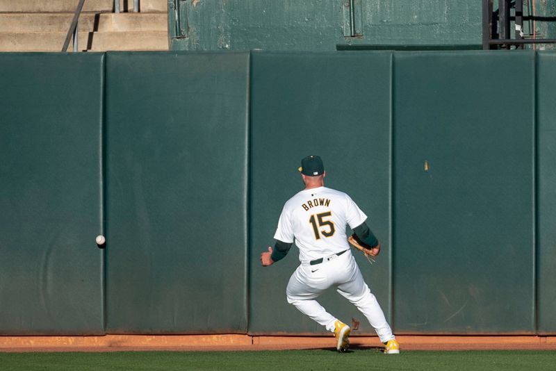 Jun 4, 2024; Oakland, California, USA; Oakland Athletics outfielder Seth Brown (15) runs down the ball hit by Seattle Mariners outfielder Luke Raley (20, not pictured) during the third inning at Oakland-Alameda County Coliseum. Mandatory Credit: Ed Szczepanski-USA TODAY Sports