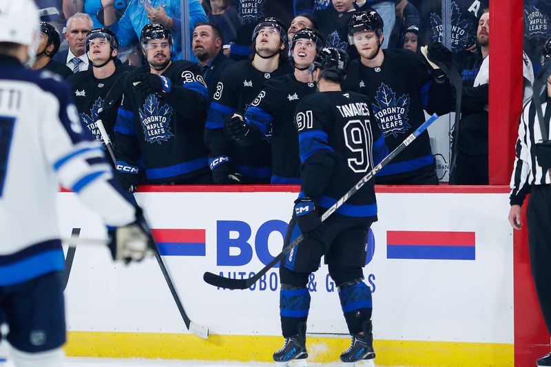 Oct 28, 2024; Winnipeg, Manitoba, CAN;  Toronto Maple Leafs forward John Taveres (91) celebrates with teammates after scoring a goal against the Winnipeg Jets during the first period at Canada Life Centre. Mandatory Credit: Terrence Lee-Imagn Images