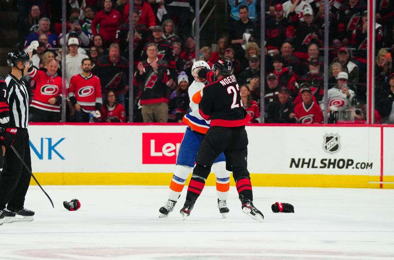 Apr 22, 2024; Raleigh, North Carolina, USA; Carolina Hurricanes right wing Stefan Noesen (23) and New York Islanders center Kyle MacLean (32) fight during the first period in game two of the first round of the 2024 Stanley Cup Playoffs at PNC Arena. Mandatory Credit: James Guillory-USA TODAY Sports