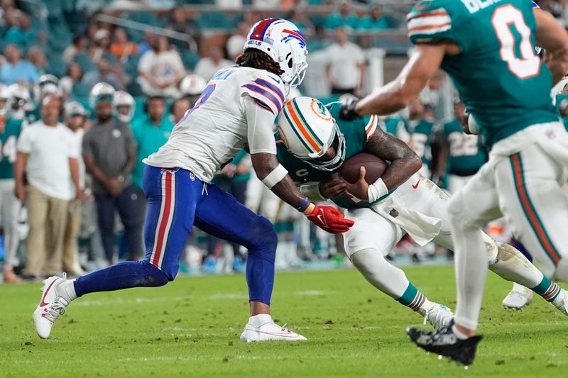 Miami Dolphins quarterback Tua Tagovailoa (1) and Buffalo Bills safety Damar Hamlin (3) collide during the second half of an NFL football game, Thursday, Sept. 12, 2024, in Miami Gardens, Fla. Tagovailoa suffered a concussion on the play. (AP Photo/Lynne Sladky)