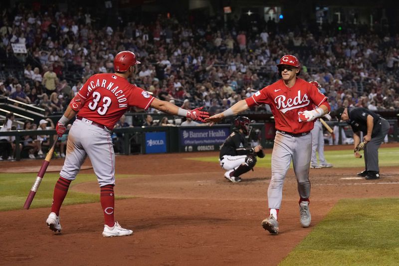 Aug 26, 2023; Phoenix, Arizona, USA; Cincinnati Reds center fielder TJ Friedl (29) slaps hands with Cincinnati Reds first baseman Christian Encarnacion-Strand (33) after scoring a run against the Arizona Diamondbacks during the 11th inning at Chase Field. Mandatory Credit: Joe Camporeale-USA TODAY Sports