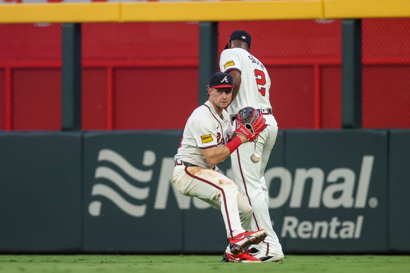 Aug 1, 2024; Atlanta, Georgia, USA; Atlanta Braves center fielder Jarred Kelenic (24) drops the ball transitioning to the glove after running into right fielder Jorge Soler (2) looks on against the Miami Marlins in the fifth inning at Truist Park. Mandatory Credit: Brett Davis-USA TODAY Sports
