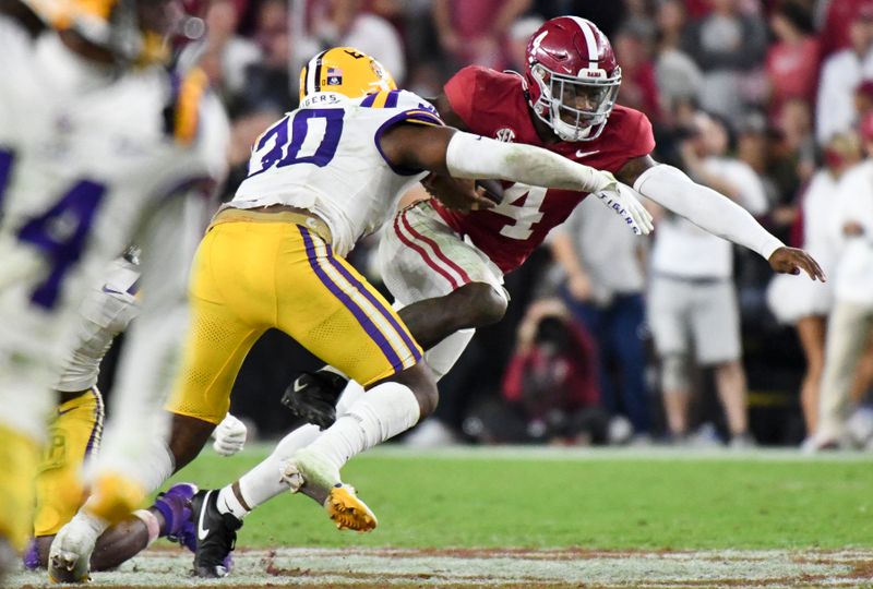 Nov 4, 2023; Tuscaloosa, Alabama, USA;  LSU Tigers linebacker Greg Penn III (30) makes a tackle on Alabama Crimson Tide quarterback Jalen Milroe (4) at Bryant-Denny Stadium. Alabama defeated LSU 42-28. Mandatory Credit: Gary Cosby Jr.-USA TODAY Sports