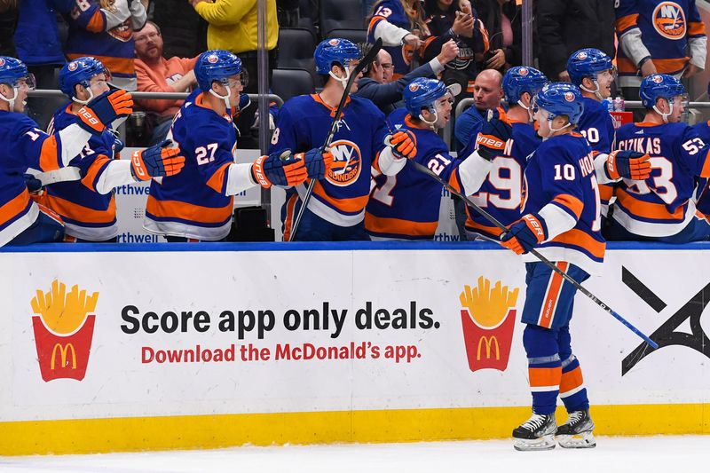 Dec 13, 2023; Elmont, New York, USA; New York Islanders right wing Simon Holmstrom (10) celebrates his short handed game winning goal against the Anaheim Ducks with the New York Islanders bench during the third period at UBS Arena. Mandatory Credit: Dennis Schneidler-USA TODAY Sports