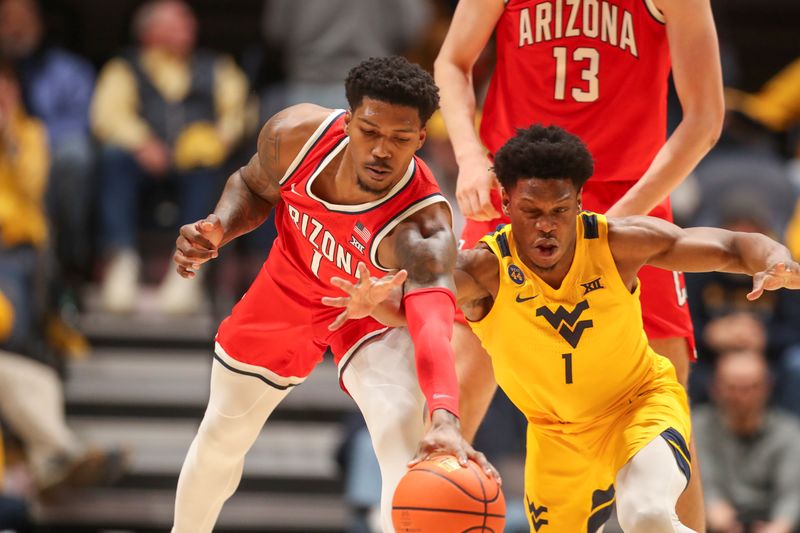 Jan 7, 2025; Morgantown, West Virginia, USA; Arizona Wildcats guard Caleb Love (1) and West Virginia Mountaineers guard Joseph Yesufu (1) fight for a loose ball during the first half at WVU Coliseum. Mandatory Credit: Ben Queen-Imagn Images
