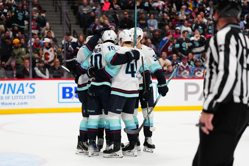 Nov 5, 2024; Denver, Colorado, USA; Members of the Seattle Kraken celebrate a goal score in the first period against the Colorado Avalanche at Ball Arena. Mandatory Credit: Ron Chenoy-Imagn Images