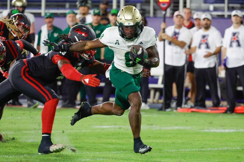 Nov 1, 2024; Boca Raton, Florida, USA;  South Florida Bulls running back Kelley Joiner (8) gets past Florida Atlantic Owls defensive end Chris Jones (49) during the second half at FAU Stadium. Mandatory Credit: Reinhold Matay-Imagn Images