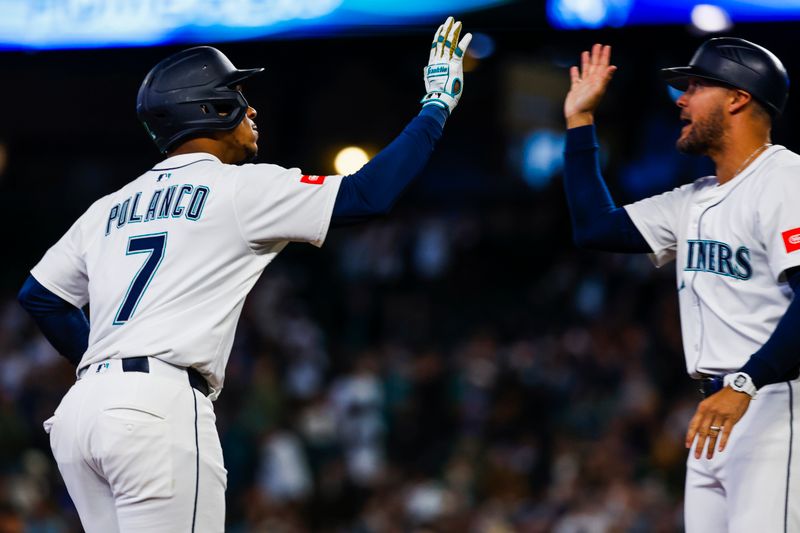 Apr 29, 2025; Seattle, Washington, USA; Seattle Mariners designated hitter Jorge Polanco (7) high-fives third base coach Kristopher Negron (45) after hitting a three-run home run against the Los Angeles Angels during the second inning at T-Mobile Park. Mandatory Credit: Joe Nicholson-Imagn Images