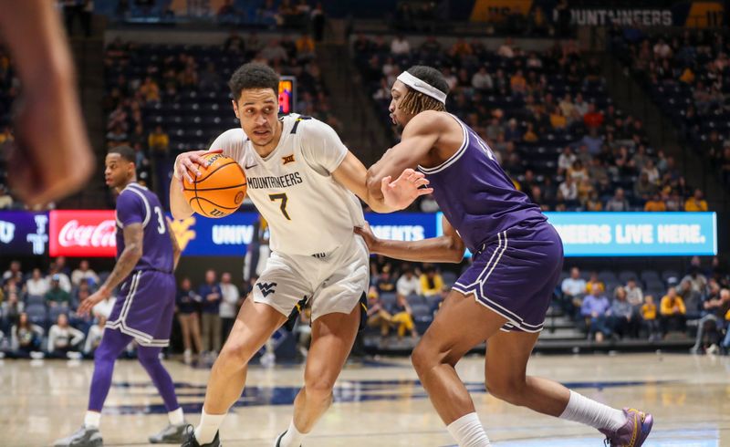 Mar 6, 2024; Morgantown, West Virginia, USA; West Virginia Mountaineers center Jesse Edwards (7) drives against TCU Horned Frogs forward Xavier Cork (12) during the second half at WVU Coliseum. Mandatory Credit: Ben Queen-USA TODAY Sports