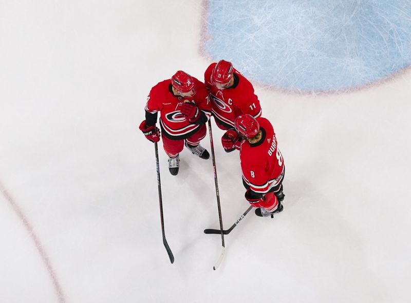 Mar 2, 2024; Raleigh, North Carolina, USA; Carolina Hurricanes center Jordan Staal (11) defenseman Brent Burns (8) and defenseman Jaccob Slavin (74) talk against the Winnipeg Jets during the first period at PNC Arena. Mandatory Credit: James Guillory-USA TODAY Sports