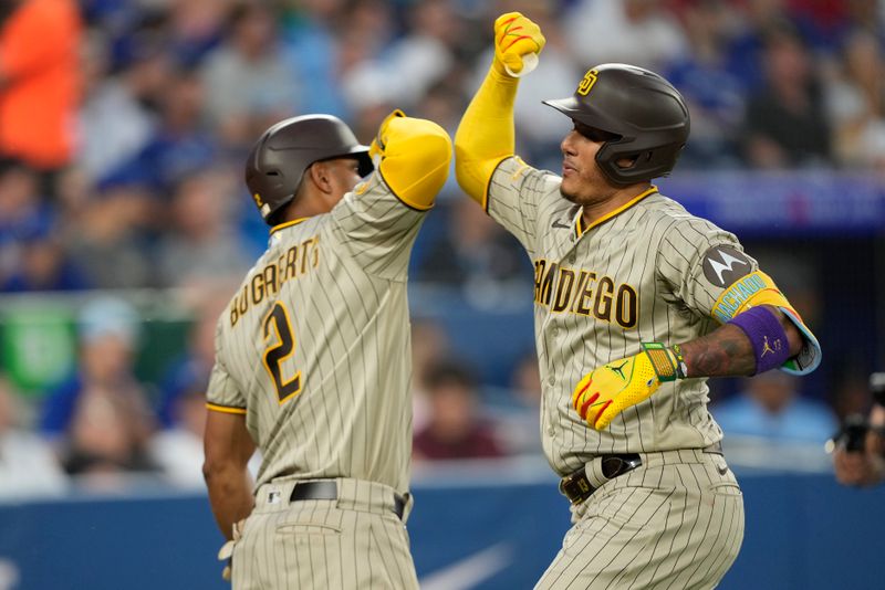 Jul 18, 2023; Toronto, Ontario, CAN; San Diego Padres third baseman Manny Machado (13) celebrates his solo home run against the Toronto Blue Jays with San Diego Padres shortstop Xander Bogaerts (2) during the fifth inning at Rogers Centre. Mandatory Credit: John E. Sokolowski-USA TODAY Sports