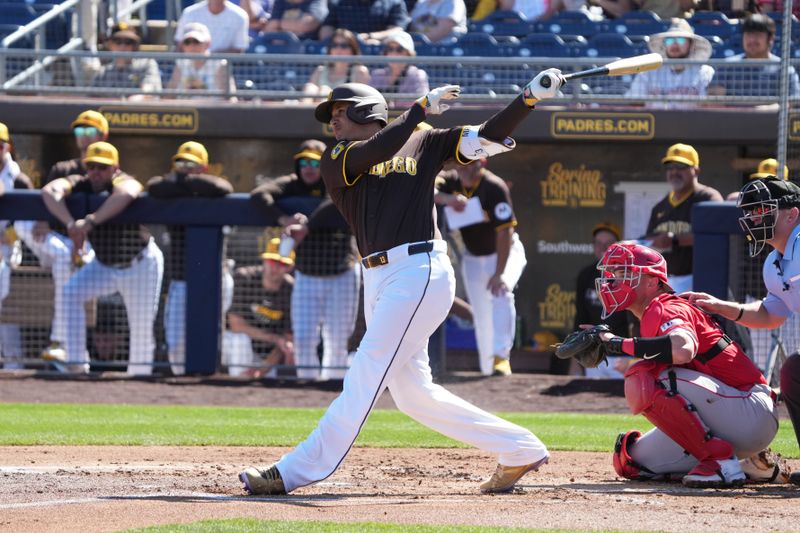 Feb 25, 2025; Peoria, Arizona, USA; San Diego Padres third base Manny Machado (13) hits a double against the Los Angeles Angels during the first inning at Peoria Sports Complex. Mandatory Credit: Rick Scuteri-Imagn Images