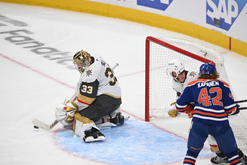 May 12, 2025; Edmonton, Alberta, CAN; Vegas Golden Knights goalie Adin Hill (33) controls the puck with Edmonton Oilers right winger Kasperi Kapanen (42) during the third period in game three of the second round of the 2025 Stanley Cup Playoffs at Rogers Place. Mandatory Credit: Walter Tychnowicz-Imagn Images