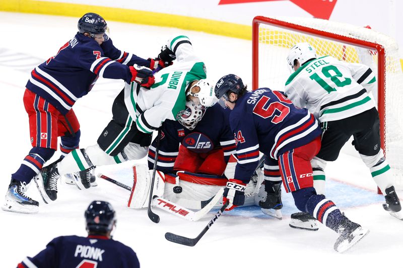 Nov 9, 2024; Winnipeg, Manitoba, CAN; Winnipeg Jets goaltender Connor Hellebuyck (37) blocks a shot against the Dallas Stars in the third period at Canada Life Centre. Mandatory Credit: James Carey Lauder-Imagn Images