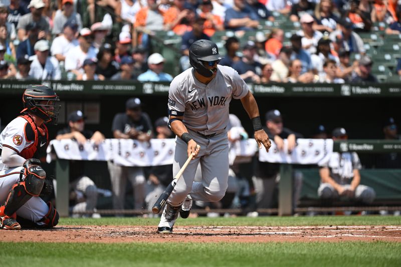 Jul 14, 2024; Baltimore, Maryland, USA;  New York Yankees outfielder Trent Grisham (12) hits an RBI single during the second inning against the Baltimore Orioles at Oriole Park at Camden Yards. Mandatory Credit: James A. Pittman-USA TODAY Sports