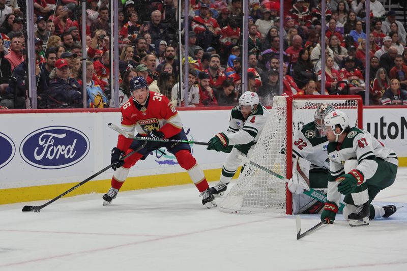 Oct 22, 2024; Sunrise, Florida, USA; Florida Panthers right wing Patrick Giles (36) moves the puck behind the net against Minnesota Wild defenseman Jon Merrill (4) during the second period at Amerant Bank Arena. Mandatory Credit: Sam Navarro-Imagn Images