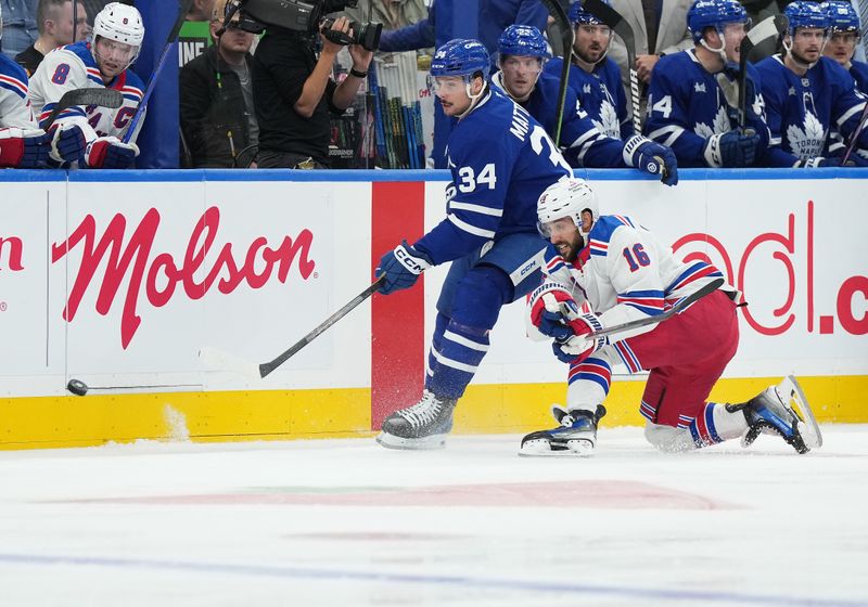 Oct 19, 2024; Toronto, Ontario, CAN; Toronto Maple Leafs center Auston Matthews (34) battles for the puck with New York Rangers center Vincent Trocheck (16) during the second period at Scotiabank Arena. Mandatory Credit: Nick Turchiaro-Imagn Images