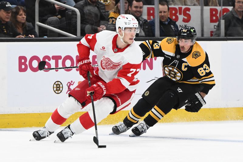 Dec 3, 2024; Boston, Massachusetts, USA; Detroit Red Wings defenseman Simon Edvinsson (77) controls the puck against Boston Bruins left wing Brad Marchand (63) during the third period at the TD Garden. Mandatory Credit: Brian Fluharty-Imagn Images