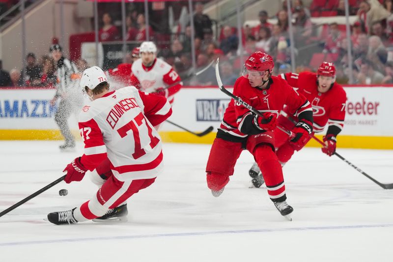 Feb 28, 2026; Raleigh, North Carolina, USA;  Detroit Red Wings defenseman Simon Edvinsson (77) blocks the puck away from Carolina Hurricanes right wing Jackson Blake (53) during the third period at Lenovo Center. Mandatory Credit: James Guillory-Imagn Images