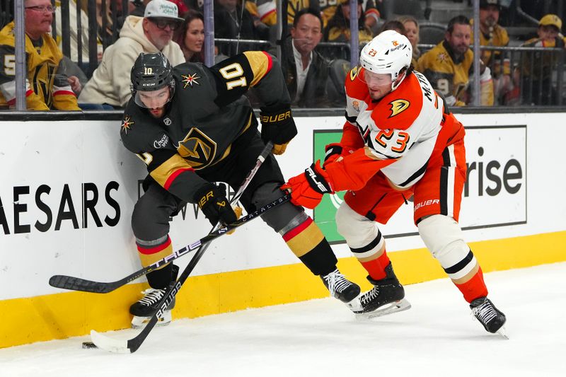 Oct 13, 2024; Las Vegas, Nevada, USA; Anaheim Ducks center Mason McTavish (23) attempts to check Vegas Golden Knights center Nicolas Roy (10) off the puck during the second period at T-Mobile Arena. Mandatory Credit: Stephen R. Sylvanie-Imagn Images