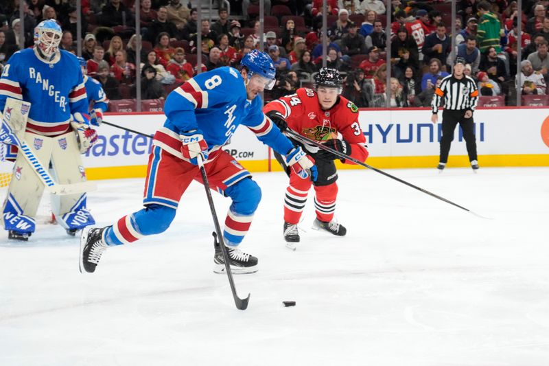 Dec 10, 2025; Chicago, Illinois, USA; New York Rangers center J.T. Miller (8) and Chicago Blackhawks center Colton Dach (34) go for the puck during the second period at United Center. Mandatory Credit: David Banks-Imagn Images