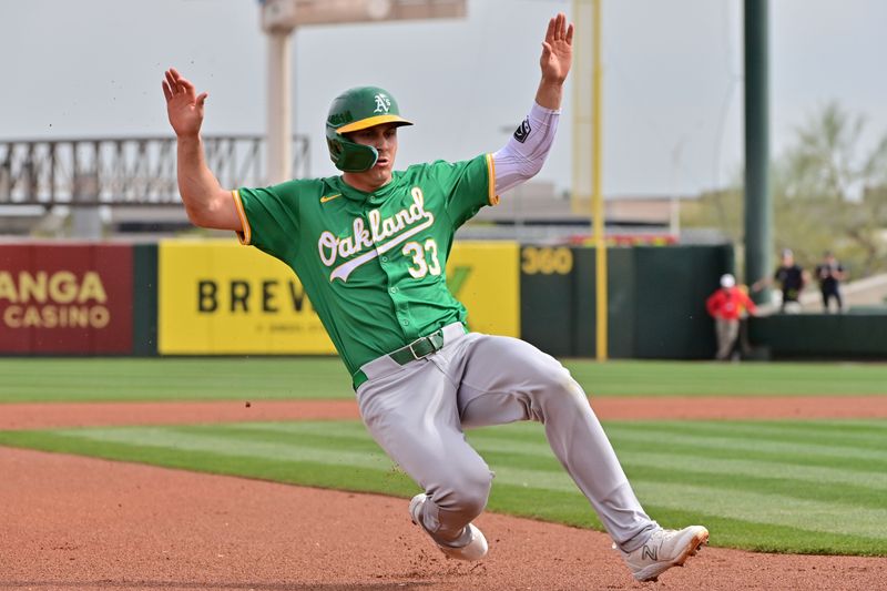 Mar 6, 2024; Tempe, Arizona, USA;  Oakland Athletics left fielder JJ Bleday (33) slides into third base in the first inning against the Los Angeles Angels during a spring training game at Tempe Diablo Stadium. Mandatory Credit: Matt Kartozian-USA TODAY Sports