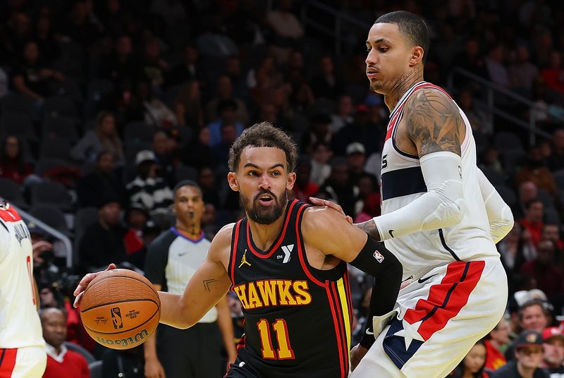 ATLANTA, GEORGIA - NOVEMBER 15:  Trae Young #11 of the Atlanta Hawks drives against Kyle Kuzma #33 of the Washington Wizards during the fourth quarter of the Emirates NBA Cup game at State Farm Arena on November 15, 2024 in Atlanta, Georgia.  NOTE TO USER: User expressly acknowledges and agrees that, by downloading and/or using this photograph, user is consenting to the terms and conditions of the Getty Images License Agreement.  (Photo by Kevin C. Cox/Getty Images)