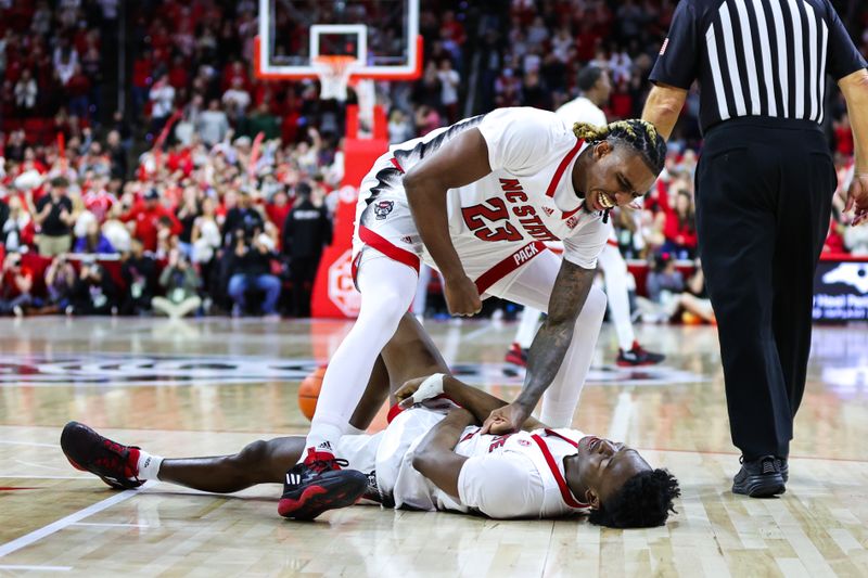 Jan 14, 2023; Raleigh, North Carolina, USA; North Carolina State Wolfpack forward Ebenezer Dowuona (21) and guard Jarkel Joiner (1) celebrate during the overtime against Miami Hurricanes at PNC Arena. Mandatory Credit: Jaylynn Nash-USA TODAY Sports