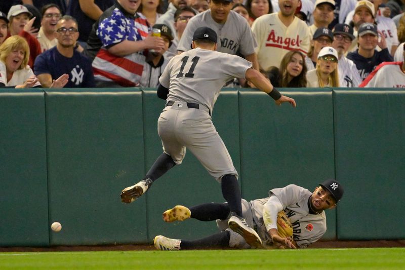 May 26, 2025; Anaheim, California, USA;  New York Yankees third baseman Oswald Peraza (18) and shortstop Anthony Volpe (11) avoid a collision as they go after a foul ball hit by Los Angeles Angels shortstop Kevin Newman (10) in the fifth inning at Angel Stadium. Mandatory Credit: Jayne Kamin-Oncea-Imagn Images
