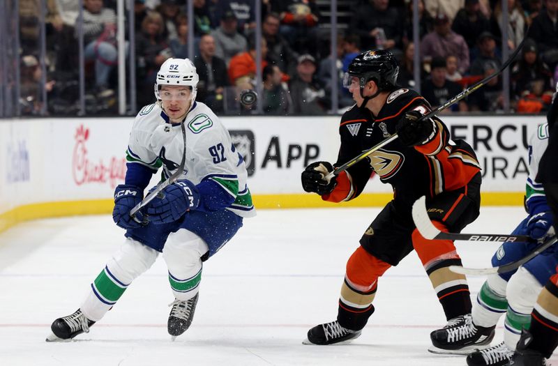 Mar 3, 2024; Anaheim, California, USA; Vancouver Canucks right wing Vasily Podkolzin (92) passes in front of Anaheim Ducks center Isac Lundestrom (21) during the third period at Honda Center. Mandatory Credit: Jason Parkhurst-USA TODAY Sports