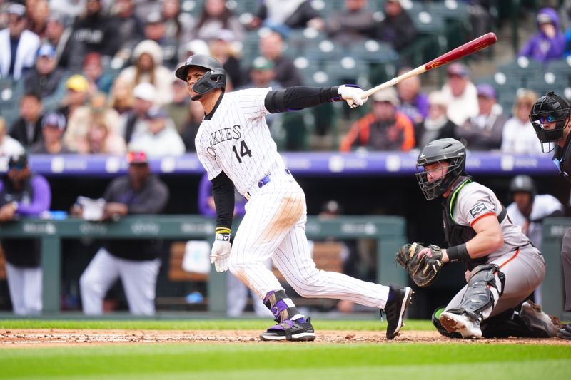 May 9, 2024; Denver, Colorado, USA; Colorado Rockies shortstop Ezequiel Tovar (14) triples in the fourth inning against the San Francisco Giants at Coors Field. Mandatory Credit: Ron Chenoy-USA TODAY Sports