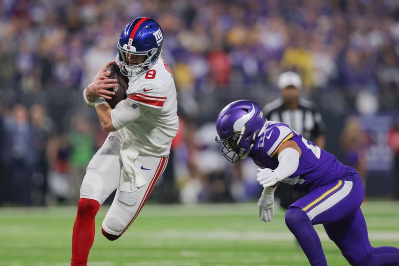 New York Giants quarterback Daniel Jones (8) handles the ball against Minnesota Vikings linebacker Eric Kendricks (54) during the first half of an NFL wild-card football game Sunday, Jan. 15, 2023 in Minneapolis. (AP Photo/Stacy Bengs)