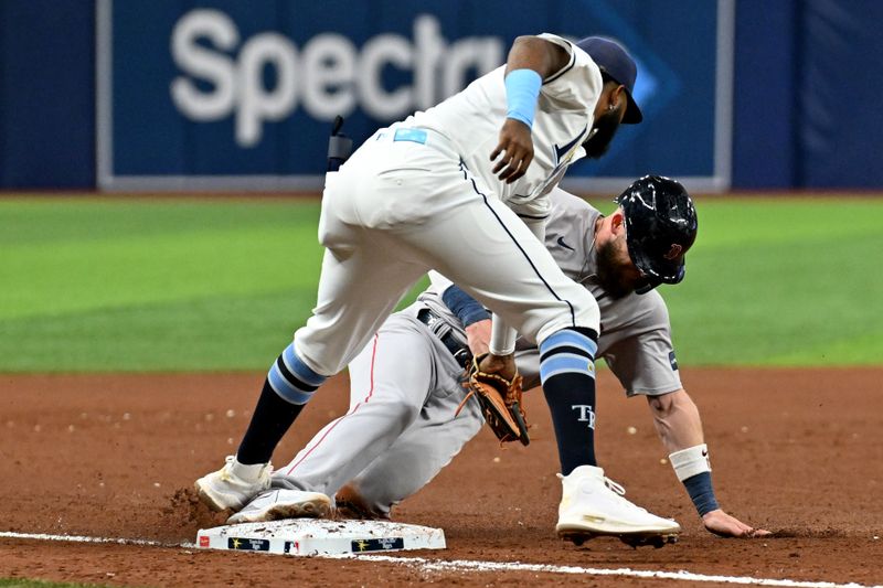 Sep 18, 2024; St. Petersburg, Florida, USA; Boston Red Sox shortstop Trevor Story (10) slides under the tag of Tampa Bay Rays third baseman Junior Caminero (13) in the eighth inning at Tropicana Field. Mandatory Credit: Jonathan Dyer-Imagn Images