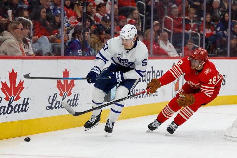Dec 28, 2025; Detroit, Michigan, USA;  Toronto Maple Leafs defenseman Philippe Myers (51) skates with the puck defended by Detroit Red Wings center Andrew Copp (18) in the second period at Little Caesars Arena. Mandatory Credit: Rick Osentoski-Imagn Images