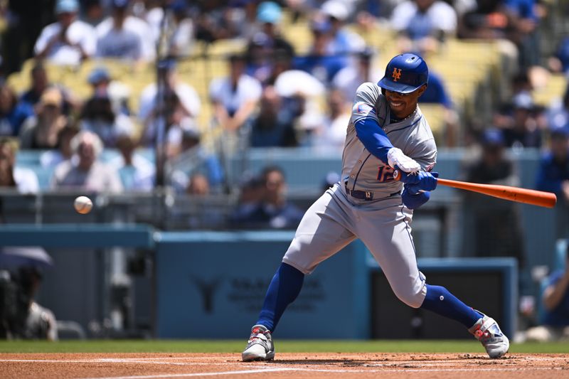 Apr 20, 2024; Los Angeles, California, USA; New York Mets shortstop Francisco Lindor (12) hits one run double against the Los Angeles Dodgers during the first inning at Dodger Stadium. Mandatory Credit: Jonathan Hui-USA TODAY Sports