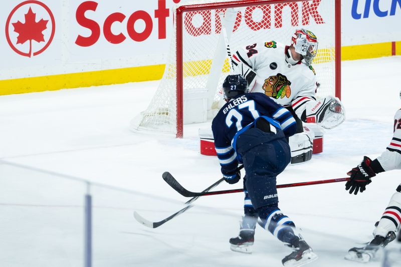 Jan 11, 2024; Winnipeg, Manitoba, CAN; Winnipeg Jets forward Nikolaj Ehlers (27) scores against Chicago Blackhawks goalie Petr Mrazek (34) during the third period at Canada Life Centre. Mandatory Credit: Terrence Lee-USA TODAY Sports