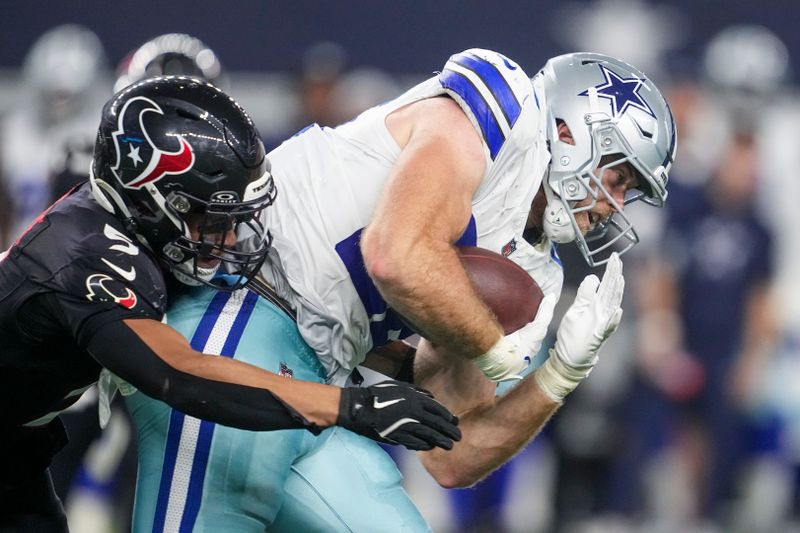 Dallas Cowboys tight end Luke Schoonmaker, right, is tackled by Houston Texans safety Jalen Pitre during the second half of an NFL football game, Monday, Nov. 18, 2024, in Arlington, Texas. (AP Photo/Tony Gutierrez)