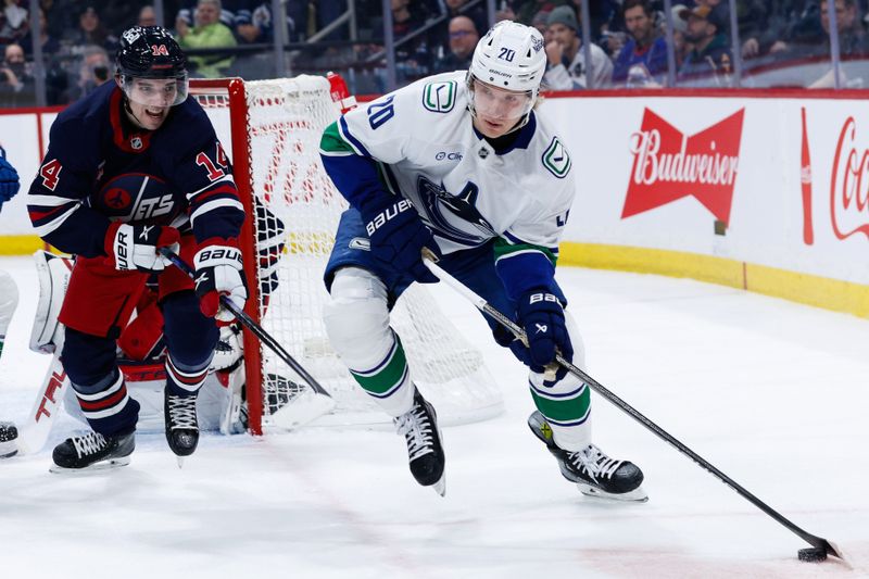 Jan 14, 2025; Winnipeg, Manitoba, CAN;  Vancouver Canucks forward Danton Heinen (20) skates away from Winnipeg Jets defenseman Ville Heinola (14) during the first period at Canada Life Centre. Mandatory Credit: Terrence Lee-Imagn Images