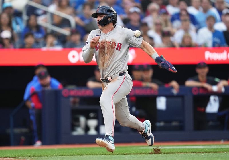 Jun 19, 2024; Toronto, Ontario, CAN; Boston Red Sox center fielder Romy Gonzalez (23) gets hit with a ball while running for home plate against the Toronto Blue Jays during the third inning at Rogers Centre. Mandatory Credit: Nick Turchiaro-USA TODAY Sports