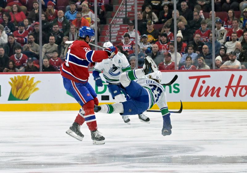 Jan 6, 2025; Montreal, Quebec, CAN; Montreal Canadiens defenseman Kaiden Guhle (21) checks Vancouver Canucks forward Jonathan Lekkerimaki (23) during the first period at the Bell Centre. Mandatory Credit: Eric Bolte-Imagn Images