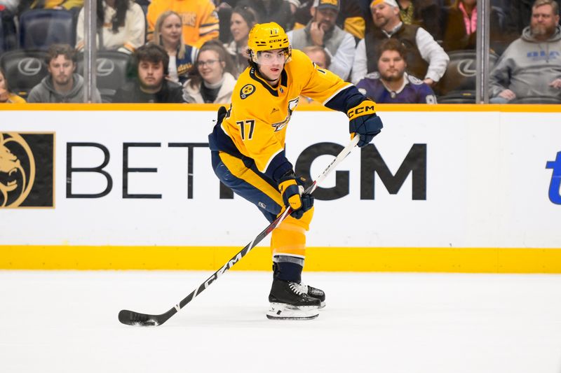 Nov 29, 2024; Nashville, Tennessee, USA;  Nashville Predators right wing Luke Evangelista (77) passes the puck against the Tampa Bay Lightning during the second period at Bridgestone Arena. Mandatory Credit: Steve Roberts-Imagn Images