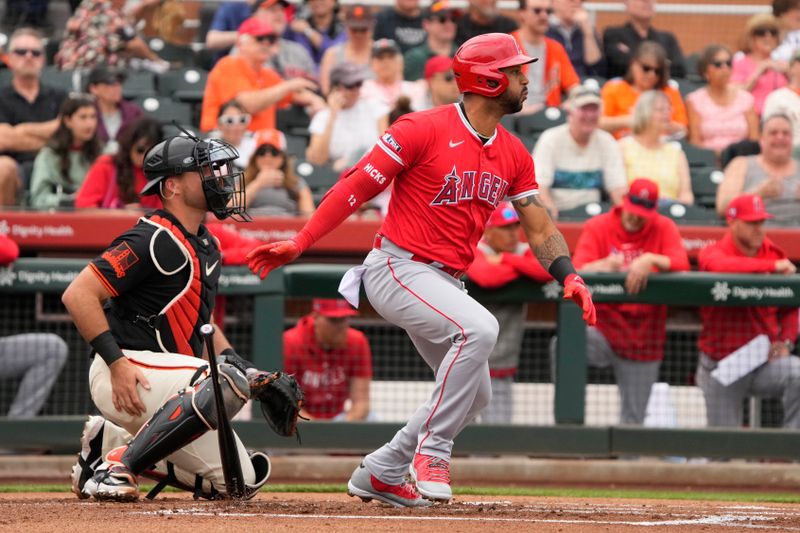 Feb 26, 2024; Scottsdale, Arizona, USA; Los Angeles Angels center fielder Aaron Hicks (12) hits a single against the San Francisco Giants in the first inning at Scottsdale Stadium. Mandatory Credit: Rick Scuteri-USA TODAY Sports