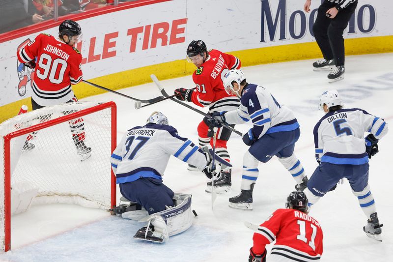 Feb 23, 2024; Chicago, Illinois, USA; Chicago Blackhawks left wing Anthony Beauvillier (91) tries to score against Winnipeg Jets goaltender Connor Hellebuyck (37) during the first period at United Center. Mandatory Credit: Kamil Krzaczynski-USA TODAY Sports