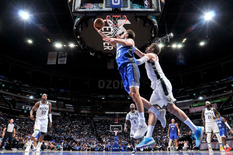 ORLANDO, FL - APRIL 14: Franz Wagner #22 of the Orlando Magic drives to the basket during the game as Brook Lopez #11 of the Milwaukee Bucks plays defense on April 14, 2024 at Kia Center in Orlando, Florida. NOTE TO USER: User expressly acknowledges and agrees that, by downloading and or using this photograph, User is consenting to the terms and conditions of the Getty Images License Agreement. Mandatory Copyright Notice: Copyright 2024 NBAE (Photo by Fernando Medina/NBAE via Getty Images)