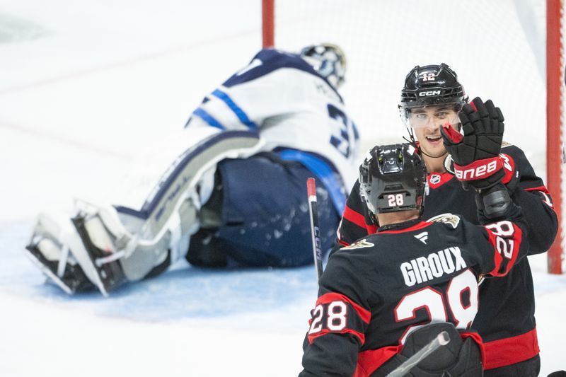 Jan 3, 2026; Ottawa, Ontario, CAN; Ottawa Senators center Shane Pinto (12) celebrates a goal scored by right wing Claude Giroux (28) against Winnipeg Jets goalie Connor Hellebuyck (37) in the third period at the Canadian Tire Centre. Mandatory Credit: Marc DesRosiers-IMAGN Images
